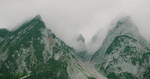 Rugged mountain range partially covered in mist with dramatic rocky peaks