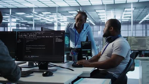 Team of Technicians Using PC to Check for System Failures in Data Center