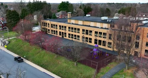 School building in USA. Aerial in spring. Education theme. Outdoor yellow brick building.
