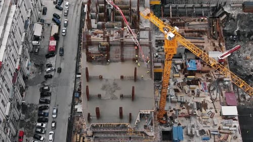 Top Down View of Construction Site with Construction Crane Workers Pouring Concrete