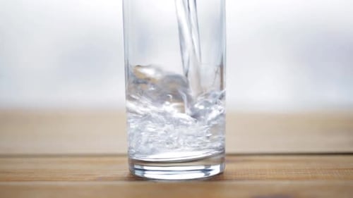 Pouring Refreshing Water into a Clear Glass