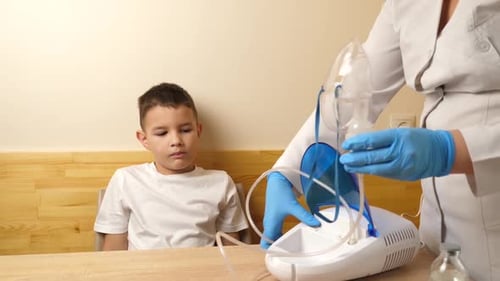 25, The boy is preparing for the nebulizer inhalation procedure.