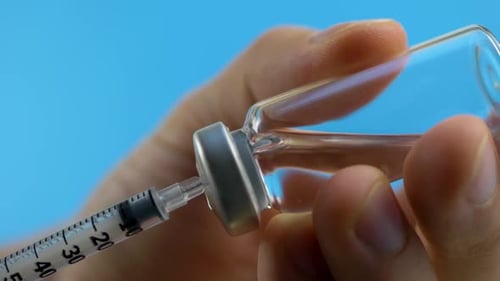 Medical Professional Hand Handles Syringe While Preparing Vaccine