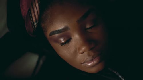 One contemplative young African American woman close-up face with solemn but slight worried