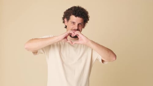 Man Gestures a Heart Shape with His Hands