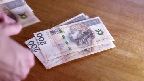 Man counts money, cash Polish zloty, close-up 200 PLN, money on the table