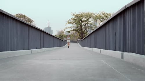 Young fitness woman in sportswear jogging in city park