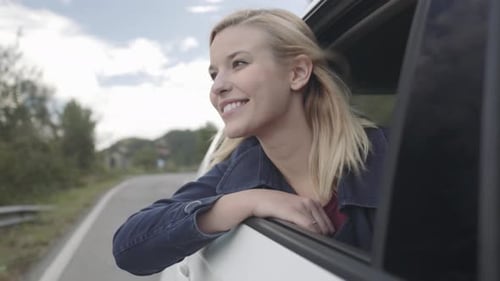 Happy Woman Enjoys Car Ride on Country Road