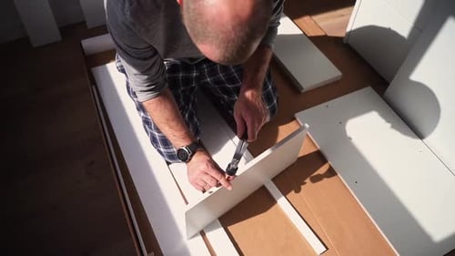 Caucasian Man Assembles Furniture Fit Table or Mount Wardrobe