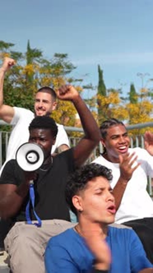 Enthusiastic Group of Sports Fans Cheering at Stadium