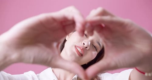 Woman Smiling Making Heart Shape with Hands