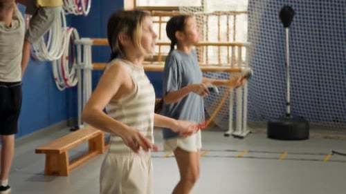 Two Girls Doing Jumping Rope Exercises in Gym
