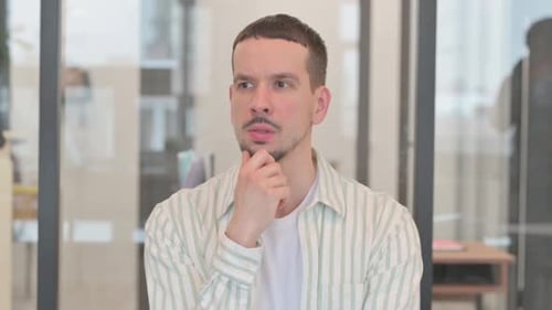 Porträt eines nachdenklichen kreativen jungen Mannes, der über neue Ideen denkt