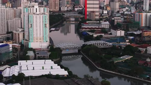 High Angle View of Vehicles Passing on Steel Road Bridge Over River Tilt Up Reveal Cityscape with
