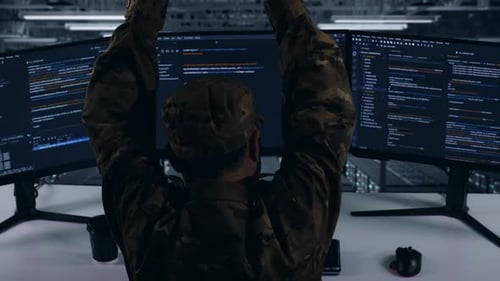 Back View Of Tired Asian Military Stretching While Write Code In Data Center