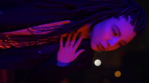Stylish Woman Posing with Braids at Night