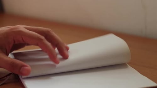 Hand Flips Through a Bullet Journal's Pages