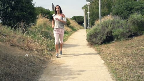 Tired sporty woman resting after jogging workout in park super slow motion 240fps