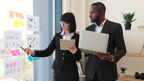 Diverse Office Workers Checking Data Using Electronic Device