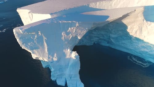 Giant Antarctic Blue Iceberg Cave in Sunset Light