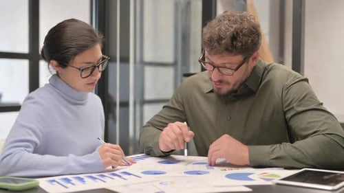Business Meeting Analyzing Data Charts in Office