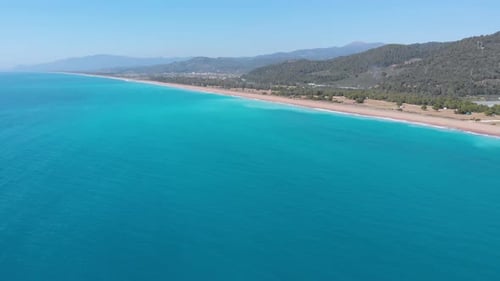 Aerial beautiful beach and water bay in the greek spectacular coast line. Turquoise blue transparent