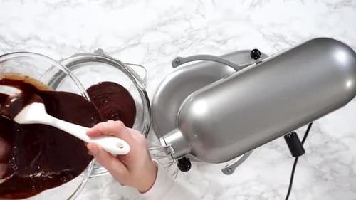 Pouring Rich Chocolate Batter into Glass Bowl
