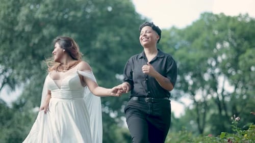 Happy Lesbian Couple Runs Hand-in-Hand in Park