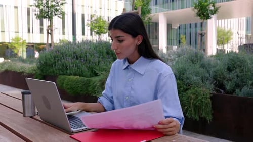 Young Businesswoman Working Online Sitting Outside Over Company Building