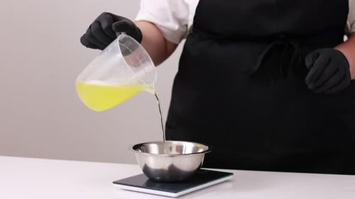 Pouring Yellow Liquid into Bowl on Scale