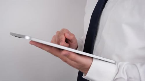 Adult Using Silver Tablet Device Indoors