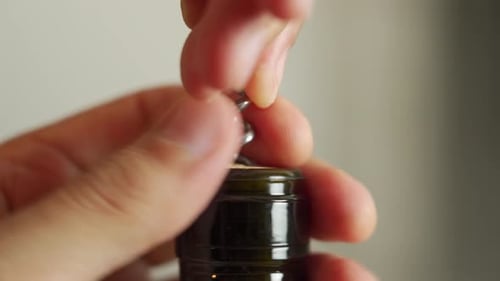 Extreme close up of a bottle of red wine being opened with a corkscrew