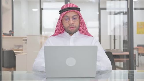 Man Video Conferencing on Laptop in Office
