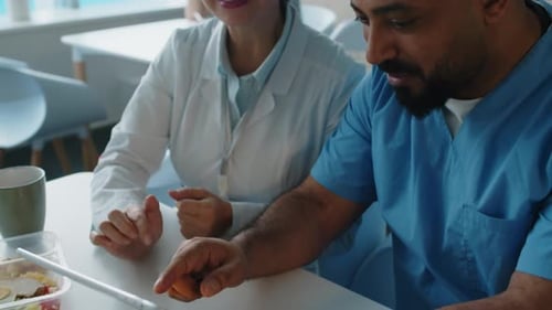 Medical Professionals Collaborating on Tablet in Modern Workplace