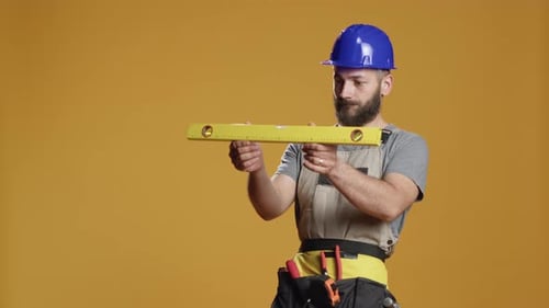 Construction Builder Working with Water Level Tool to Do Measurement