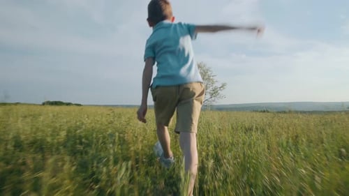 Child Running Wild in Summer Field Back View of Freedom in Nature