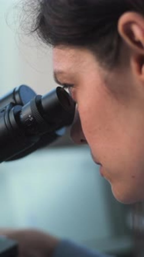 Close Up of Young Scientist Using Microscope Analyzing Sample