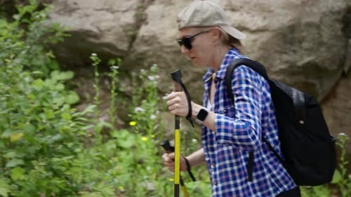 Woman Hiking with Walking Sticks in Nature