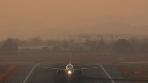 Airplane Taking off at Sunrise from Airport Runway