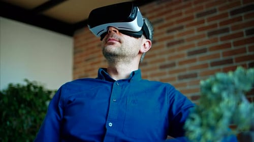 Man gesturing while using a Virtual Reality headset in an office
