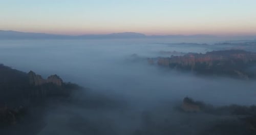 Aerial view of foggy mountains and valley, Italy.