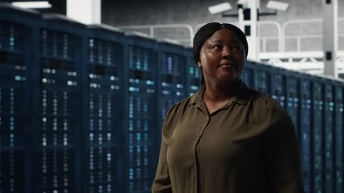 Portrait of Smiling Admin Walking in Data Center Overseeing IT Infrastructure