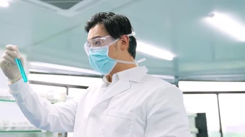 Scientist Examining Colorful Test Tubes in Laboratory