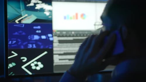 A Dedicated Professional in Technology Monitoring on Call Who Manages Multiple Screens Effectively