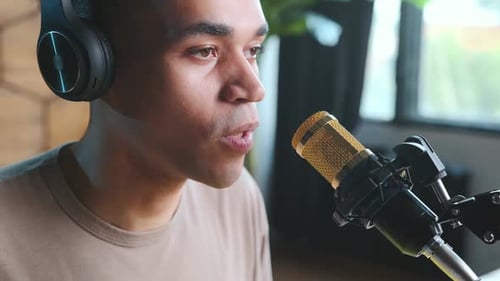 Young Adult Speaking Into Microphone with Headphones