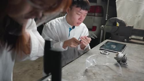 Un technicien ajuste l'étrier Vernier pendant qu'une dame observe dans un atelier de laboratoire