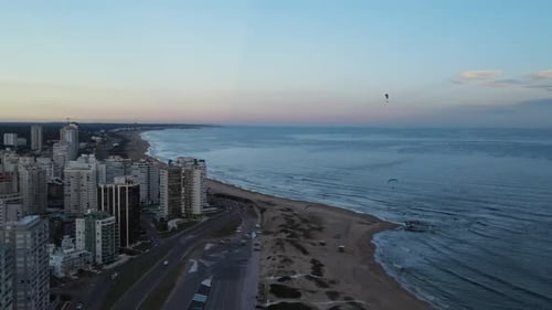 Urban Coastline with Beach and Parasailors at Sunrise