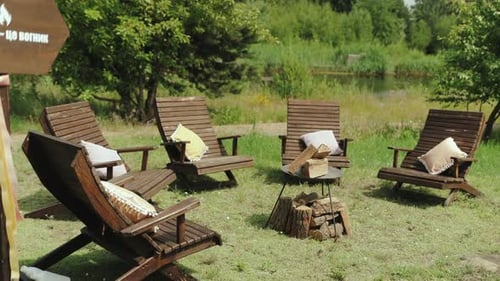 Campfire Area Wooden Chairs with Small Pillow on It Around Fire Pit Outside in Nature in Yard Sunny
