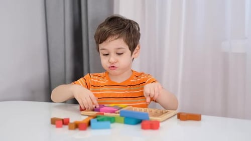 Close Up of Child's Hands Playing with Colorful Wooden Bricks at the Table Stock Footage Slow Motion