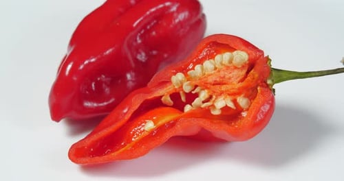 Two Red Peppers on a White Surface